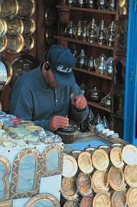 Modern craftsman enjoys music while he works - Sidi Bou Said, Tunisia