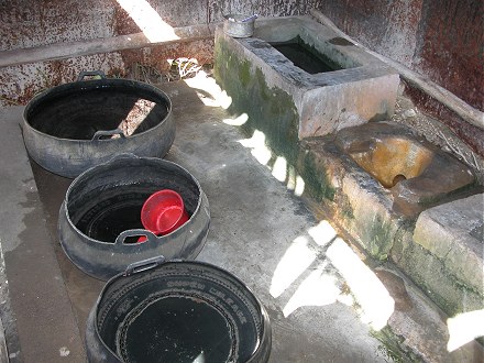 Dip bucket shower and toilet. Old tyres as water storage.