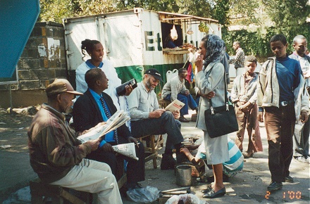 Reading a magazine while getting shoes shined in Addis Ababa