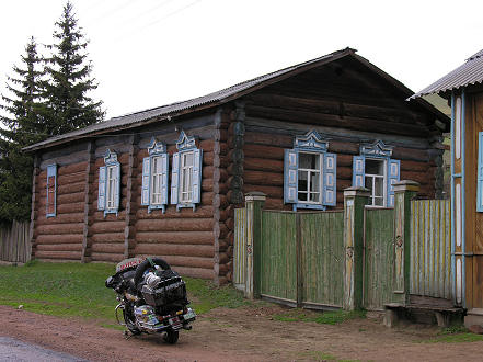 Log houses all with decorated and blue painted window frames