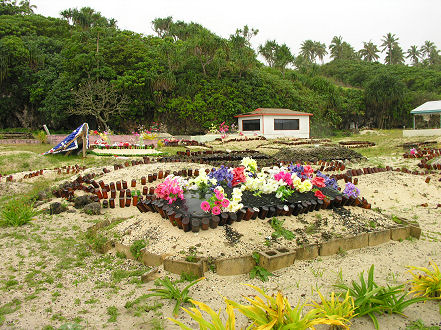 Plastic flowers and beer botles decorate cemeteries