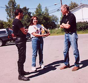 BMW riders Ken and Deb White (left) share road stories with Don Rosene, owner of The Motorcycle Shop in Anchorage.