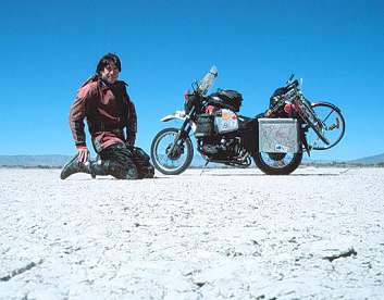 Greg on lake bed, bicycle loaded on the motorcycle