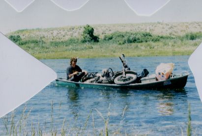 Gregory paddling a canoe, with the bike in it!